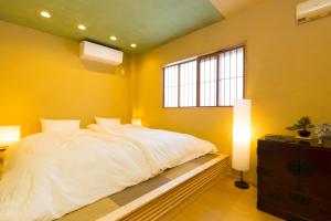 a bedroom with a white bed and a window at Cha Cha An in Osaka