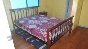 a bed with a purple and white comforter on it at Orchid Beach Retreat Orchid Beach Fraser Island in K'gari Island (Fraser Island)