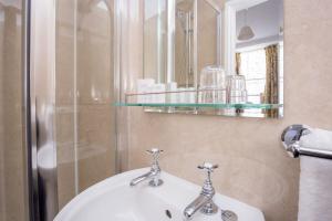 a bathroom with a white sink and a mirror at The Queens Hotel in Penzance +68 photos