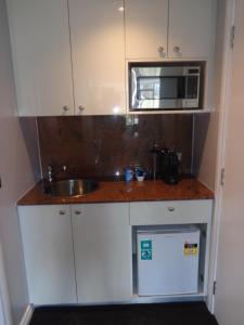 a small kitchen with a sink and a microwave at PrivateStudio in Quay West Building in Melbourne