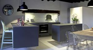Cazeaux-de-LarboustにあるMaison Eth Bordac & Bordac Petitのキッチン(青いキャビネット、テーブル、椅子付)