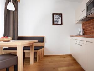 a small kitchen with a wooden table and a dining room at Ferienwohnungen Eiblhuber in Tannheim