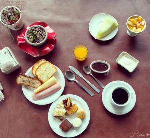 una mesa con platos de comida y una taza de café en La Posada De Madryn en Puerto Madryn