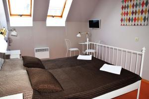 1 dormitorio con 1 cama y TV en la pared en Liberty, en Riga