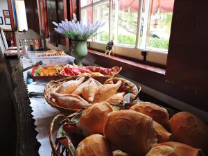 a table topped with baskets of bread and a window at Pousada Araujo Bazilio in Tiradentes