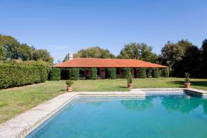 una piscina di fronte a una casa con gazebo di Pazo de Brandeso & Country Club a Arzúa