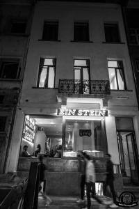 Gente caminando por la noche frente a un restaurante en Villa Einstein Apartments, en Amberes