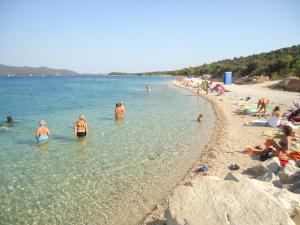 a group of people in the water at a beach at Apartmani Emily in Jezera +21 photos