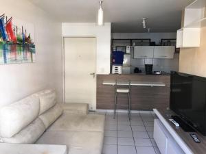 sala de estar con sofá y cocina en Apartamento Jatiuca en Maceió