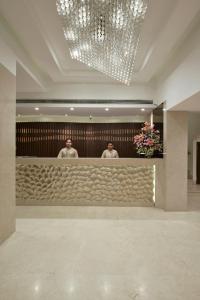 two men standing behind a bar in a lobby at Hotel Heritage formerly known as Comfort Inn Heritage in Mumbai