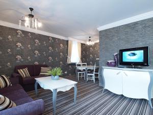 a living room with a couch and a tv at Hotel Fajkier in Kroczyce