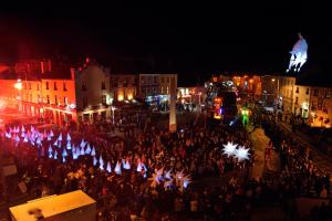 a crowd of people standing in a street at night at Apartment 263 - Clifden in Clifden