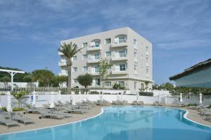 a hotel with a swimming pool in front of a building at Sunrise Gardens Aparthotel in Protaras