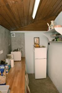 a kitchen with a white refrigerator and a wooden ceiling at Mistra Estates Villa The Vine in Pikouliánika