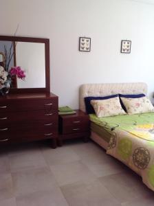 a bedroom with a bed and a dresser and a mirror at Villa Maria in Tunis