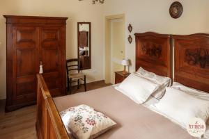 a bedroom with a large bed with a wooden headboard at Il Pettirosso in Santarcangelo di Romagna