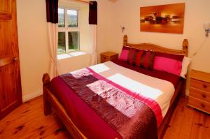 a bedroom with a bed and a window at Cottage 101 - Moyard in Letterfrack