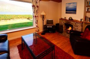 uma sala de estar com um sofá e uma lareira em Cottage 101 - Moyard em Letterfrack
