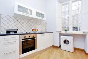 cocina con armarios blancos y lavadora en Cozy Tritone - My Extra Home, en Roma