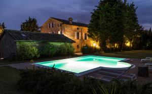 una piscina di fronte a una casa di notte di Residenza La Canonica a Novilara