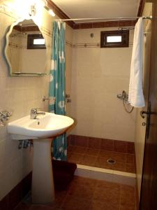 Un baño con lavabo y ducha con espejo. en Melenio Studios, en Livadi Astypalaias