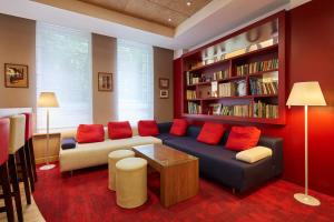 a living room with a blue couch and red pillows at Campanile Krakow Old Town in Kraków