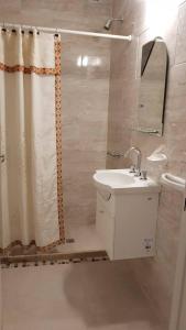 a bathroom with a sink and a shower curtain at La Pedrera in Villa María