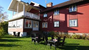 a red house with tables and chairs in front of it at Backlund Boende i Dalarna in Rättvik