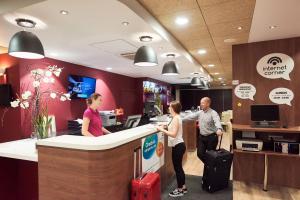 a group of people standing at a hotel counter with luggage at Campanile Krakow Old Town in Kraków