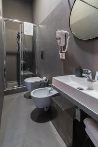 a bathroom with a toilet and a sink and a mirror at BMode in Catania
