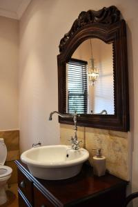 ein Bad mit einem Waschbecken und einem Spiegel in der Unterkunft Roche House in Queenstown
