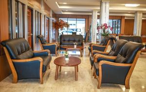 a waiting room with leather chairs and a table at Korat Hotel - SHA Plus in Nakhon Ratchasima