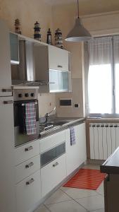 a kitchen with white appliances and a red rug at Casa Di Marta in Diano Marina