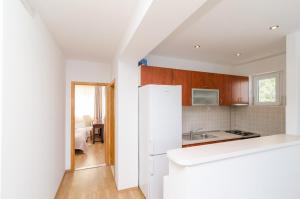 a kitchen with a white refrigerator and a bedroom at Apartments Angelo in Polače