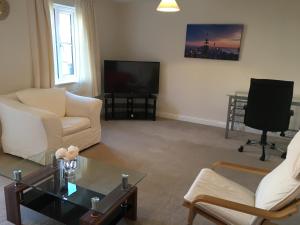 a living room with two chairs and a television at New and Comfortable with Parking in Andover