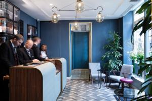 a group of people sitting at a bar in a blue room at Maison Bréguet in Paris