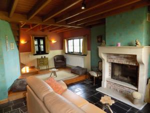 uma sala de estar com um sofá e uma lareira em Vakantiehuis Charmant em Brakel