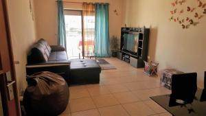een woonkamer met een bank en een tv bij Casa Sílvia in Lagos