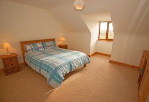 a bedroom with a bed and two night stands and a window at Cottage 238 – Cleggan in Cleggan