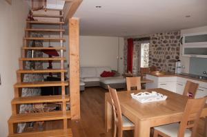 a kitchen and living room with a wooden table and chairs at Gîte de l’Eyrieux in Les Ollières-sur-Eyrieux