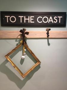 a to the coast sign on a shelf with a mirror at Rooms at number one in Broadstairs