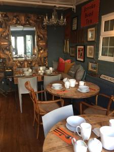 a dining room with two tables and a couch at Rooms at number one in Broadstairs