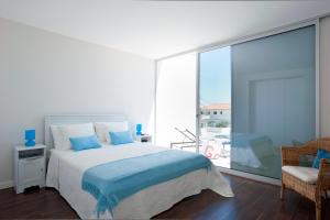 a bedroom with a bed and a large window at Seasagres - Design Villas in Sagres +24 photos