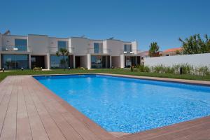a swimming pool in front of a house at Seasagres - Design Villas in Sagres