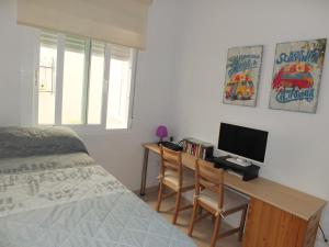 1 dormitorio con escritorio, ordenador y cama en Apartamento Mijas Costa, Las Lagunas, en Mijas Costa