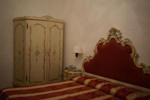 a bedroom with a bed with a red headboard at Albergo Basilea in Venice