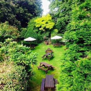 a group of picnic tables and umbrellas in a park at The Red Lion Inn & Restaurant in Prestatyn