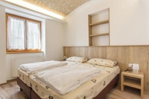 モルヴェーノにあるIl nido molvenoのベッドルーム1室(大型ベッド1台、木製ヘッドボード付)