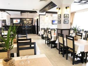 a dining room with tables and chairs in a restaurant at Pensiunea Camena in Piatra Neamţ