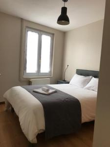 1 dormitorio con 1 cama con manta negra y ventana en Residence des portes du Velay, en Saint-Didier-en-Velay